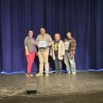 Memorial Opera House Staff pose for a picture with their Chamber Member of the Month Certificate.
